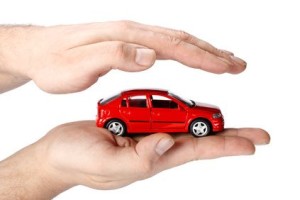 Red car in hands on a white background. Concept of safe driving